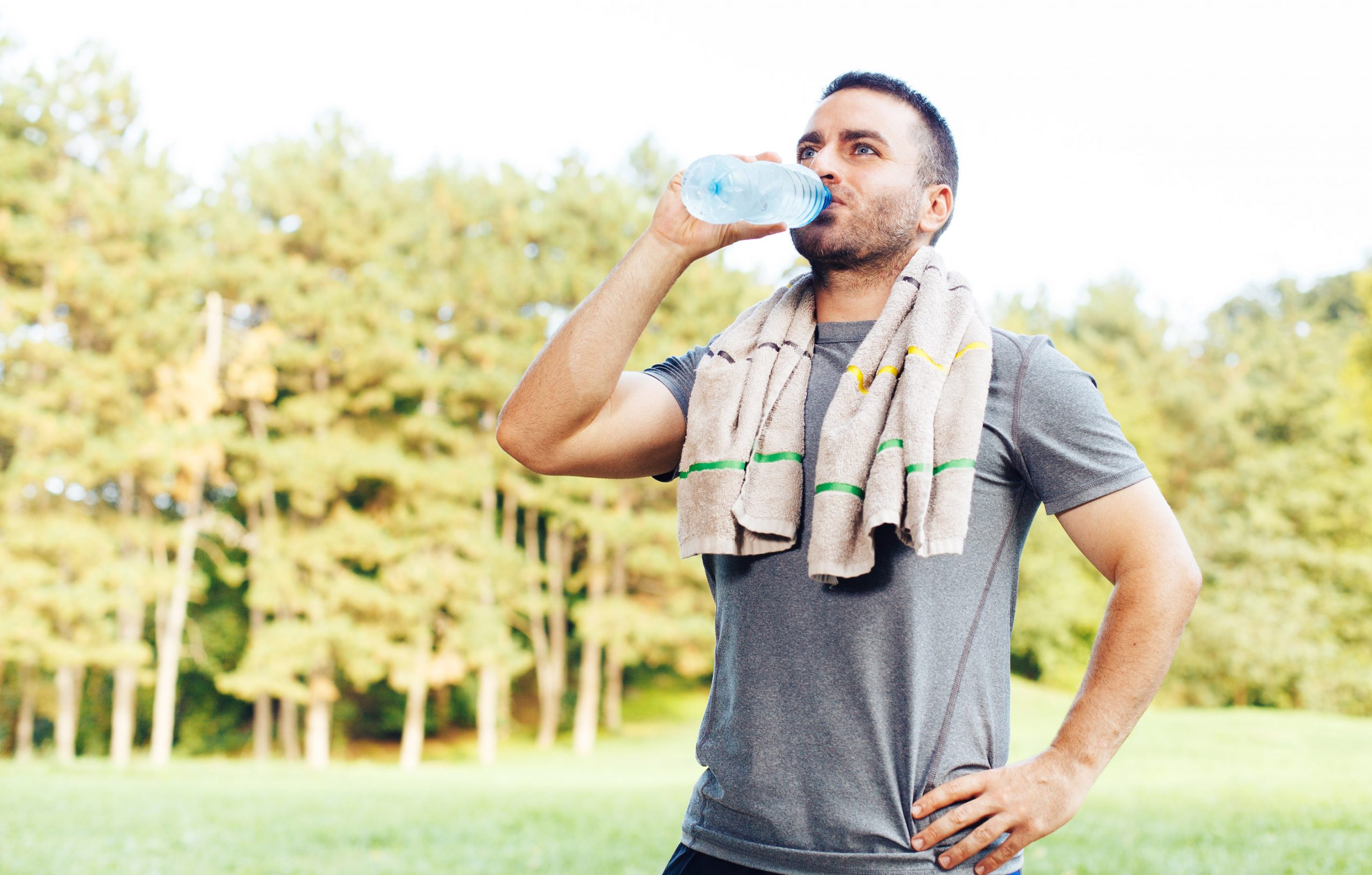 Hombre joven bebiendo agua después del entrenamiento